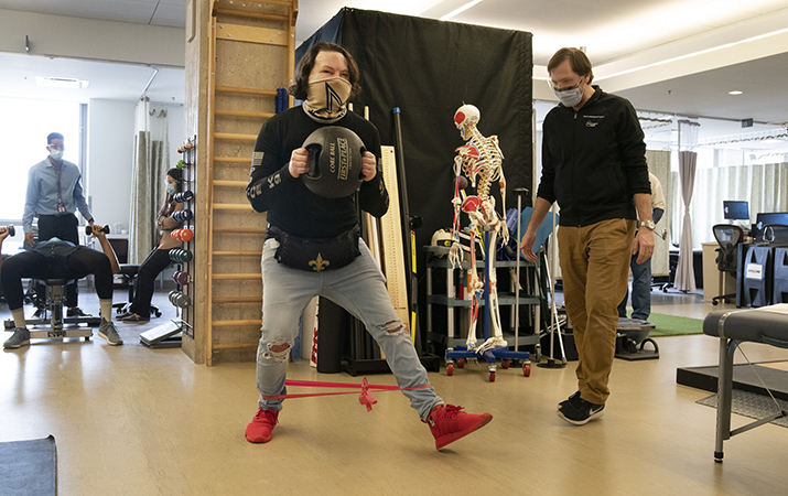 Physical therapist Eric Ross, right, watches as Joe DiMeo exercises, Monday, Jan. 25, 2021 at NYU Langone Health in New York, six months after an extremely rare double hand and face transplant. The 22-year-old New Jersey resident had the surgery last August, two years after being badly burned in a car crash.  ??sI knew it would be baby steps all the way,??? DiMeo said recently. ??sYou???ve got to have a lot of motivation, a lot of patience. And you???ve got to stay strong through everything.??? (AP Photo/Mark Lennihan)